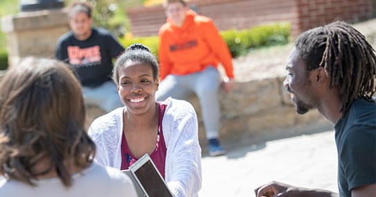 Students studying at a picnic table in Benefactors Plaza.