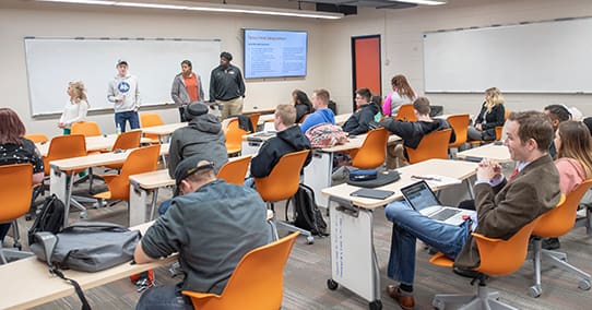 Students giving a presentation during a communication class.