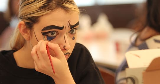 Student practices pop-art makeup during a stage make-up course.