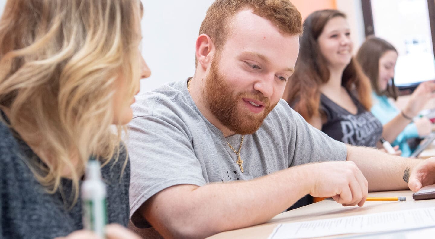 Student looking down at a whiteboard.