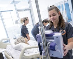nursing student checking bed side monitor in simulation lab