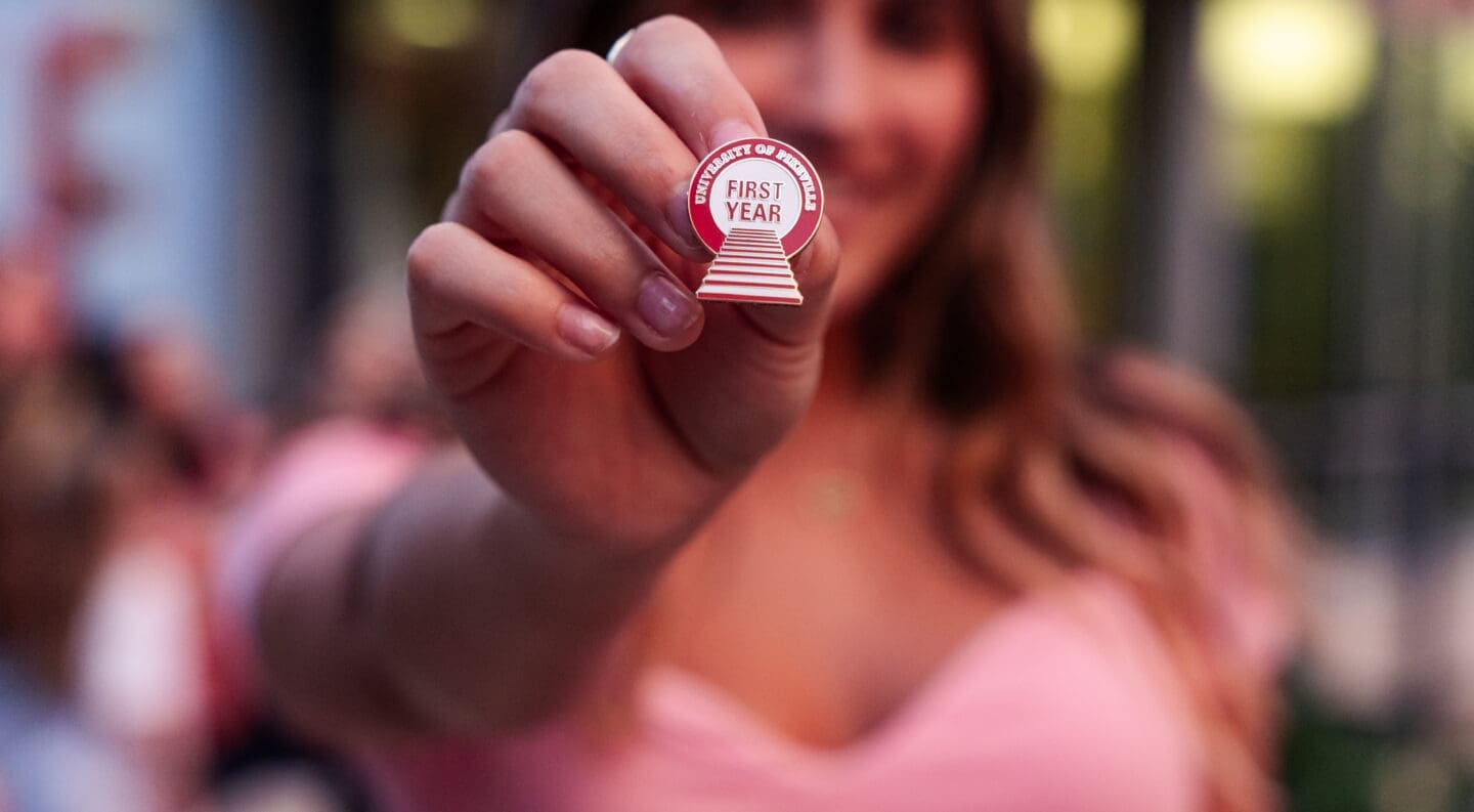 student holding first year pin during a previous climb event