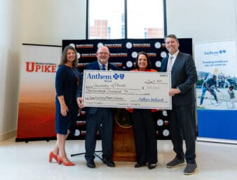 President Webb and TCDM Dean Dr. Jill Keaton accept an oversized check from Anthem