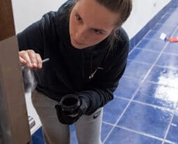 Student dusts for fingerprints in a forensics class.