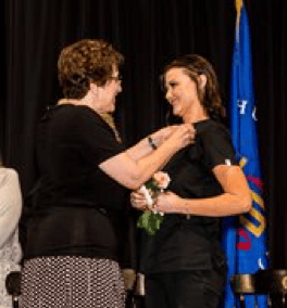 nursing student receiving her pin at Nursing Pinning ceremony