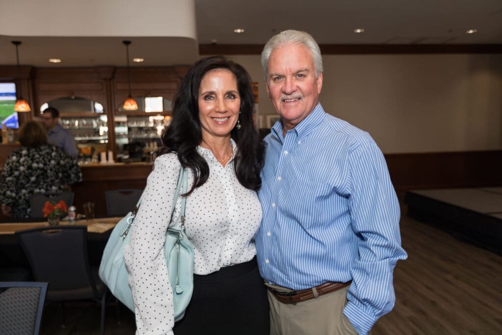 a couple pose for a photo as they enter the event