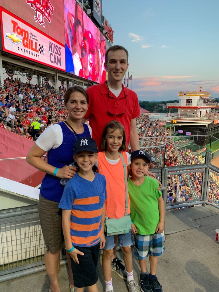Family posed in front of baseball field