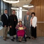 Eula holding award with Dr. Webb and Baird Family
