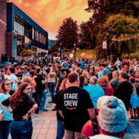 a large crowd gathers outside for the climb