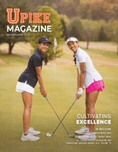 The spring cover of UPIKE magazine featuring two female golfers posing on the green and smiling.
