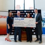 President Webb and TCDM Dean Dr. Jill Keaton accept an oversized check from Anthem
