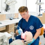 TCDM Students working on a prosthetic head with open mouth.
