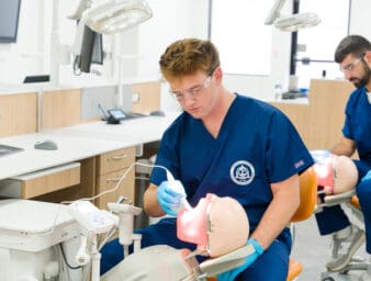 TCDM Students working on a prosthetic head with open mouth.