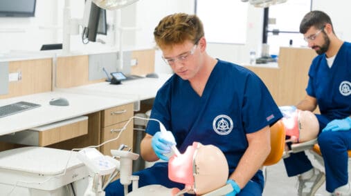 TCDM Students working on a prosthetic head with open mouth.